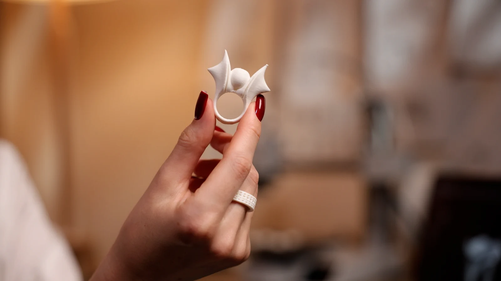 A hand holding a ring with a spiky sculptural top.
